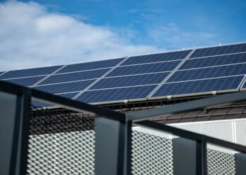 Balkonkraftwerk – Close-up view of modern solar panels on a rooftop against a clear blue sky, representing clean energy.