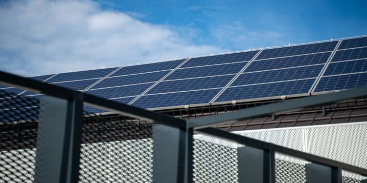 Balkonkraftwerk – Close-up view of modern solar panels on a rooftop against a clear blue sky, representing clean energy.