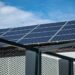 Balkonkraftwerk – Close-up view of modern solar panels on a rooftop against a clear blue sky, representing clean energy.